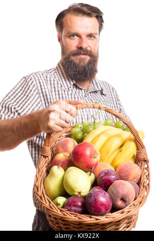 Portrait von bärtigen Mann mit Korb mit Früchten vor weißem Hintergrund Stockfoto