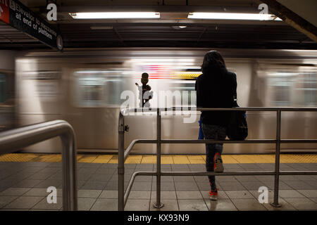 'U-Bahn' ist eine permanente öffentliche Kunstwerk geschaffen von Bildhauer Otterness für die 14. Straße - Eighth Avenue Station von NEW YORK U-Bahn Stockfoto