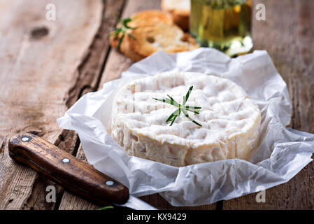 Camembert mit Rosmarin auf Holz- Hintergrund Stockfoto