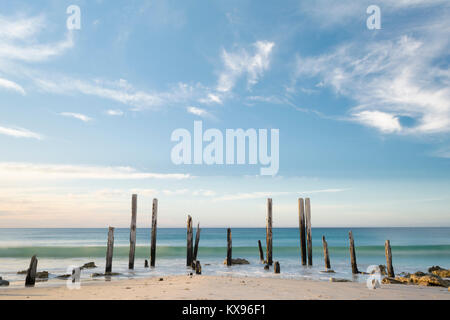 Port Willunga Strand mit der Ikonischen jetty Ruinen bei Tageslicht mit langsamen Verschlusszeit Akzentuierung der langen Welle kommt. Liegt i Stockfoto