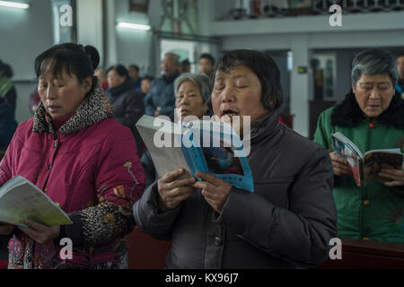 Die Gläubigen singen die Songs während der Christmette am Heiligen Herz Jesu Kirche in Housangyu Dorf, 70 km westlich von Peking entfernt, eine der frühesten Kirchen in China. 25-Dez-2017 Stockfoto