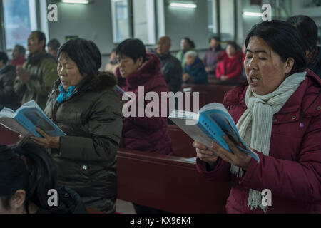 Die Gläubigen singen die Songs während der Christmette am Heiligen Herz Jesu Kirche in Housangyu Dorf, 70 km westlich von Peking entfernt, eine der frühesten Kirchen in China. 25-Dez-2017 Stockfoto