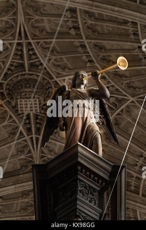 Hölzerne Statue von einem Engel mit Trompete auf der Orgel in der Kapelle des King's College, Universität Cambridge, England. Stockfoto