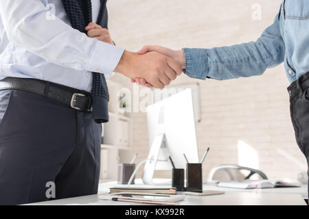 Business Partner die Hände schütteln über Tabelle Stockfoto