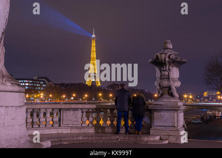 PARIS - 10. Dezember 2017: Eiffelturm bei Nacht beleuchtung und Strassenlaternen auf Alexander der dritten Brücke in Paris, Frankreich. Alexander die dritte Brid Stockfoto