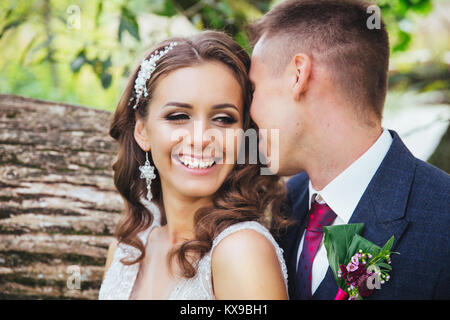 Schöne Hochzeit paar im Park. Braut und Bräutigam küssen und umarmen einander. Happy Hochzeitstag Stockfoto