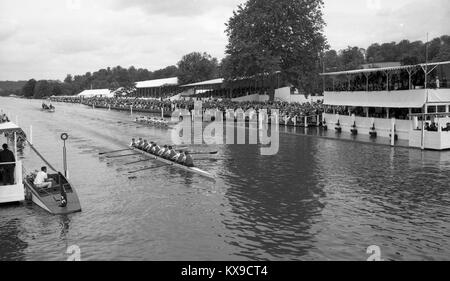 Juli 1990, Henley on Thames, Oxfordshire, England. Henley Royal Regatta Szene auf der Themse. Allgemeine Ansicht als zwei 8 erreichen die Ziellinie vor den Tribünen. Foto von Tony Henshaw Stockfoto