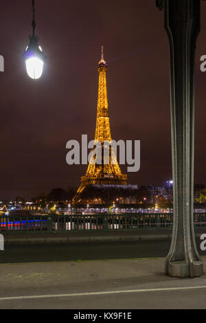 PARIS - 10. Dezember 2017: Eiffelturm bei Nacht beleuchtung und Strassenlaternen auf Alexander der dritten Brücke in Paris, Frankreich. Alexander die dritte Brid Stockfoto