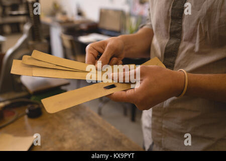 Arbeitnehmer holding Leder Blatt in der Werkstatt Stockfoto