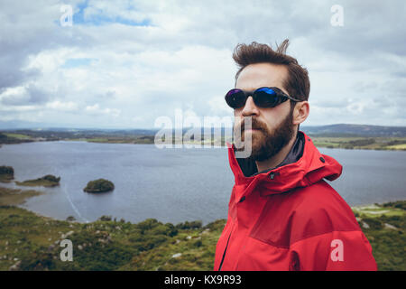 Männliche Wanderer in Sonnenbrille in der Nähe von See Stockfoto