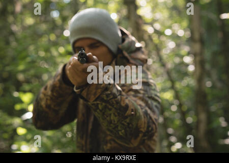 Jäger schießen mit Gewehr im Wald Stockfoto