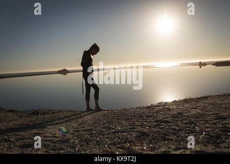 Frau in Swim Suit stand in der Nähe der Küste Stockfoto
