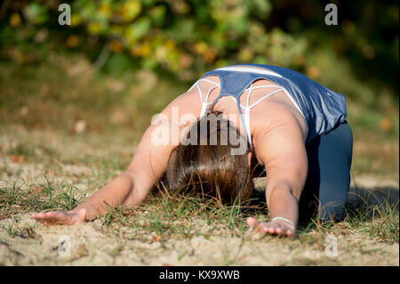 Frau Yoga in den Sand - Kind pose-Balasana - Herbst Tag Stockfoto