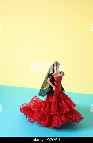 Ein typisch spanisches Puppe gekleidet wie ein Flamenco Tänzerin, mit dem charakteristischen traje de flamenca, die typischen dot-gemusterten Kleid, in Gelb und Blau Stockfoto