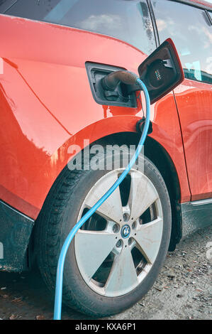 Elektrische Auto geparkt und an eine Ladestation angeschlossen Stockfoto