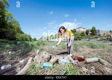 Ein Mitglied der "Stadt auf dem Meer", eine Kampagne Bristol zu befreien aus Kunststoff Flasche Abfälle sammeln von Flaschen am Ufer des Avon, Großbritannien Stockfoto