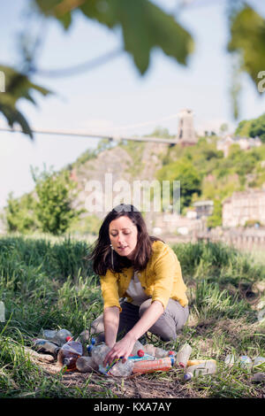 Ein Mitglied der "Stadt auf dem Meer", eine Kampagne Bristol zu befreien aus Kunststoff Flasche Abfälle sammeln von Flaschen am Ufer des Avon, Großbritannien Stockfoto