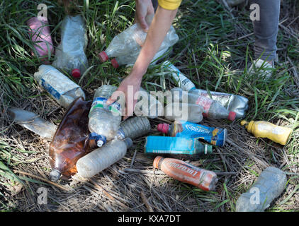 Ein Mitglied der "Stadt auf dem Meer", eine Kampagne Bristol zu befreien aus Kunststoff Flasche Abfälle sammeln von Flaschen am Ufer des Avon Stockfoto