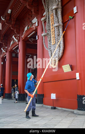 JAPAN, Tokio, 29.Juni 2017, Der Mann mit einem langen Besen reinigt Hōzōmon Gate bei Sensō-ji - eine alte buddhistische Tempel in Asakusa, Tokyo, Japan. Stockfoto