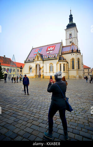 Zagreb, Kroatien. Ein Erinnerungsfoto in St. Mark's Square. Das bunte Dach der St. Mark's Church. Die Kirche von St. Mark (Kroatisch: Crkva sv. Marka) ist die Pfarrkirche der Altstadt von Zagreb, befindet sich in der St. Mark's Platz (Trg Svetog Marka). Auf dem Dach, Fliesen sind so gelegt, dass sie das Wappen von Zagreb (white castle auf rotem Hintergrund) und Dreieinigen Königreich Kroatien, Slawonien und Dalmatien vertreten. Stockfoto