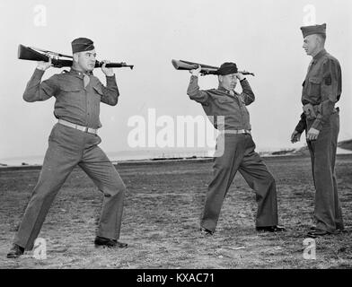 Fort Slocum, New York. James J. Braddock, ehemalige heavyweight Champion der Welt, und sein Manager, Joseph Gould, die Atlantikküste Transport Corps Offiziere Ausbildung Schule, die erst vor kurzem eröffnet. Sie haben Kommissionen des ersten lieutenants empfangen. Braddock Leutnant und Oberleutnant Gould tun Gewehr calisthenics unter Anweisung von Sergeant John A. Bender Stockfoto