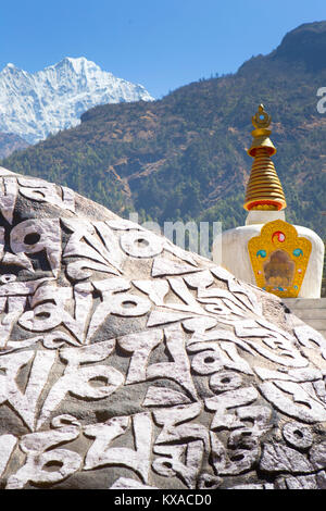 Eine buddhistische Monument, auf dem Weg zum Everest Base Camp. Mani Wände mit Mantras, einem Stupa und Gebetsfahnen. Am Abend werden Sie mit köstlichen Nepalesische Küche rund um die Küche belohnt werden - Zimmer Brand bei einem Sherpa Kaffee und Unterhalten mit anderen gleichgesinnten Reisenden. Stockfoto