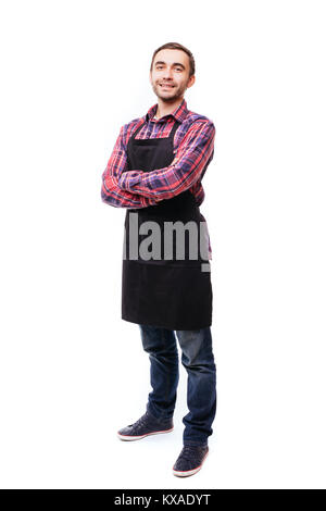 Die volle Länge der Junge Koch oder Kellner Posing, trug schwarze Schürze auf weißem Hintergrund Stockfoto