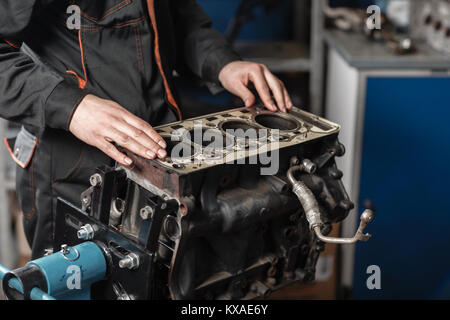 Der Mechaniker block Motor Fahrzeug zerlegen. Motor auf einer Haltevorrichtung mit Kolben und Pleuel der Kraftfahrzeugtechnik. In einer Autowerkstatt. Stockfoto