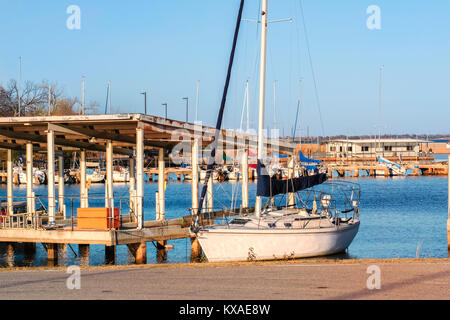 Zwei Segel Cuddy Cabin Segelboot mit eingerollt Segel festgemacht an einem Hefner Lake Marina Dock in Oklahoma City, Oklahoma, USA. Stockfoto