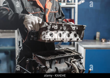 Der Mechaniker block Motor Fahrzeug zerlegen. Motor auf einer Haltevorrichtung mit Kolben und Pleuel der Kraftfahrzeugtechnik. In einer Autowerkstatt. Stockfoto