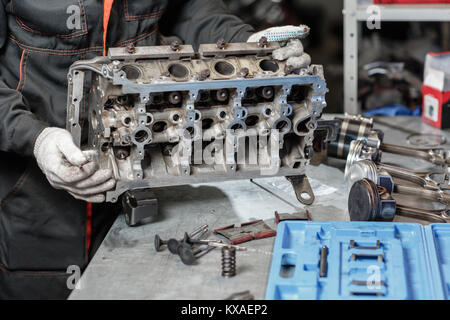 Der Job eines Mechanikers. Motorblock Fahrzeug zerlegen. Motor Hauptstadt reparieren. 16 Ventil und vier Zylinder. Auto Service Konzept. Stockfoto