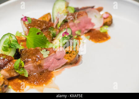 Gegrilltes Schweinefilet mit frischen sautierten Gemüse über Mango und glasnudeln. Stockfoto