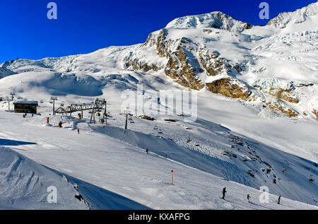 Skifahrer auf der Längfluh Skipiste vor dem schneebedeckten Alphubel, Saas-Fee, Wallis, Schweiz Stockfoto
