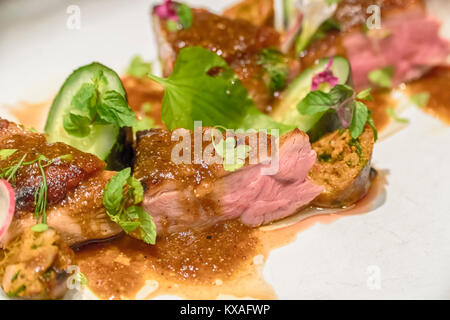 Gegrilltes Schweinefilet mit frischen sautierten Gemüse über Mango und glasnudeln. Stockfoto