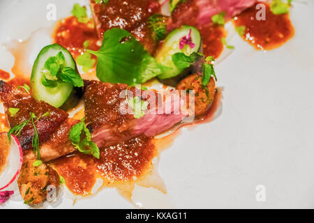 Gegrilltes Schweinefilet mit frischen sautierten Gemüse über Mango und glasnudeln. Stockfoto