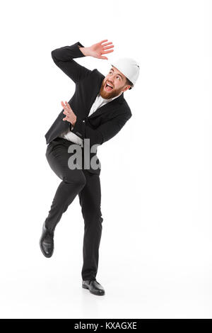 Volle Länge Bild von Angst, bärtigen business Mann in Schutzhelm selbst auf weißem Hintergrund Stockfoto