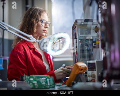 Techniker Maßnahmen mit einem Messgerät in einem Elektronik Labor, Österreich Stockfoto