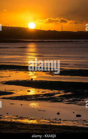 Longniddry Bents, East Lothian, Schottland, Vereinigtes Königreich. 8 Jan, 2018. Ein sehr kalter Tag zeichnet zu einem erstaunlichen Ende, mit einem orangefarbenen Sonnenuntergang über der Bucht in Richtung Edinburgh in der Ferne suchen Stockfoto