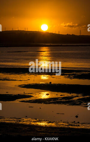 Longniddry Bents, East Lothian, Schottland, Vereinigtes Königreich. 8 Jan, 2018. Ein sehr kalter Tag zeichnet zu einem erstaunlichen Ende, mit einem orangefarbenen Sonnenuntergang über der Bucht in Richtung Edinburgh in der Ferne suchen Stockfoto