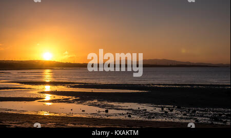 Longniddry Bents, East Lothian, Schottland, Vereinigtes Königreich. 8 Jan, 2018. Ein sehr kalter Tag zeichnet zu einem erstaunlichen Ende, mit einem orangefarbenen Sonnenuntergang über der Bucht in Richtung Edinburgh in der Ferne suchen Stockfoto