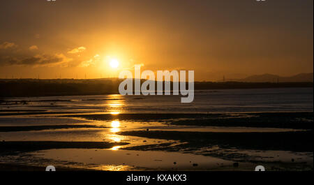 Longniddry Bents, East Lothian, Schottland, Vereinigtes Königreich. 8 Jan, 2018. Ein sehr kalter Tag zeichnet zu einem erstaunlichen Ende, mit einem orangefarbenen Sonnenuntergang über der Bucht in Richtung Edinburgh in der Ferne suchen Stockfoto