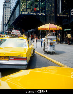 New York 1980s, gelbe Taxis, Frankfurter Wurstverkäufer Food Cart, The Grand Hyatt Hotel, East 42. Street, Manhattan, New York City, NY, NYC, USA, Stockfoto