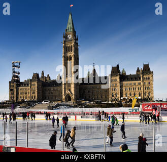 Parliament Hill Center Block Peace Tower mit Nachmittagssonne auf Skater auf dem Kanada 150 Eisbahn im Winter Ottawa Stockfoto