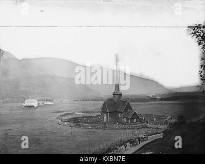 Dieses Bild zeigt die Kvikne-Kirche und die angrenzende Priesterresidenz in Norwegen und zeigt ihre traditionelle Holzarchitektur. Kirche und Residenz sind wichtige Beispiele für norwegische ländliche Baustile. Stockfoto