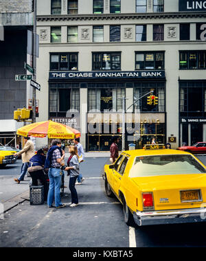 New York 1980s, gelbes Taxi, Frankfurter Würste Food Cart, Menschen, die Chase Manhattan Bank Zweigstelle, Ecke Vanderbilt Avenue und 42. Street, Manhattan, New York City, NY, NYC, USA, Stockfoto