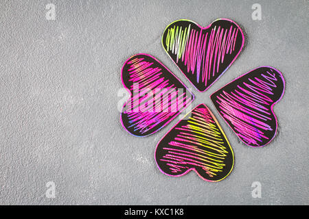 Hausgemachte schwarz violett rosa Herzen auf einem grauen konkreten Hintergrund. Das Konzept der Valentinstag. Ein Symbol der Liebe Stockfoto