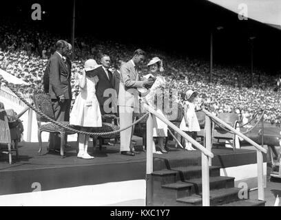 King George VI und Queen Elizabeth mit Prinzessin Elizabeth und Margaret am Festival der Jugend Wembley Stadium Juli 1937 Stockfoto