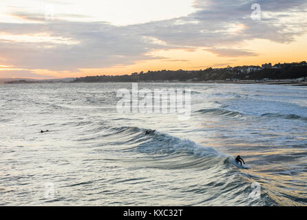 Golden Sunset über Bournemouth Strand/Meer mit Surfer Genießen der guten Swell, Bournemouth, Dorset, England, Großbritannien Stockfoto