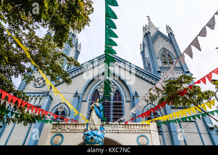 Blau Katholische Kirche mit Fahnen und Saint Mary Statue mit Engeln verziert, Puerto Princessa, Palawan. Philippinen Stockfoto