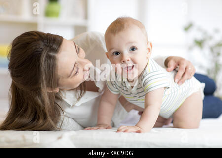 Mama und Baby boy spielen in sonnige Schlafzimmer. Eltern und Kind Kind zu Hause entspannen. Spaß für die ganze Familie zusammen. Stockfoto